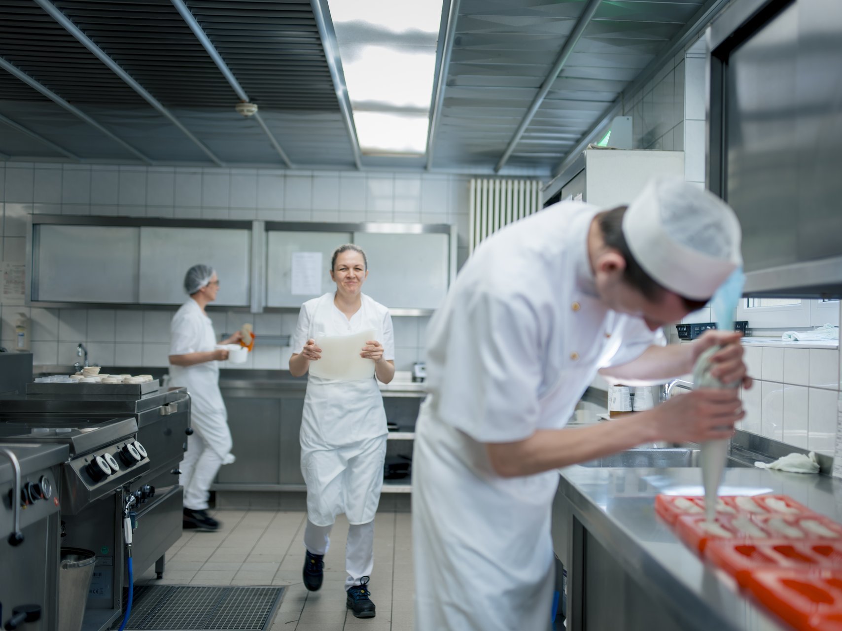 Die Mitarbeitenden der Küche arbeiten konzentriert am nächsten Mittagessen.